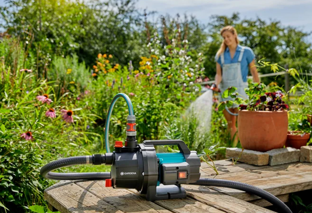 Απεικονίζεται μια γυναίκα να χρησιμοποιεί το πιεστικό για να ποτίσει.